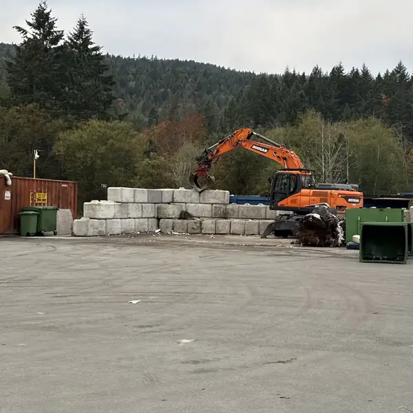 Excavator sorting material in the yard