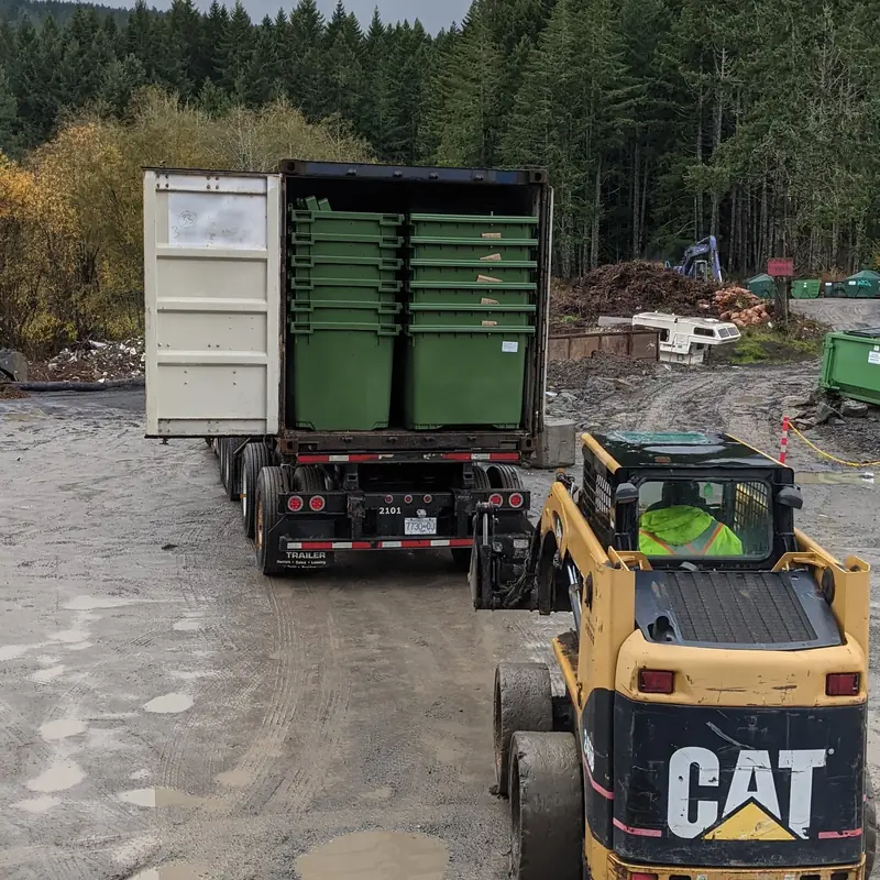 New green commercial garbage bins being unloaded at the Salt Spring Garbage yard