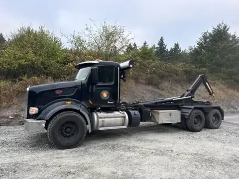Black Salt Spring Garbage & Recycling Peterbilt hook-lift truck with the company decal